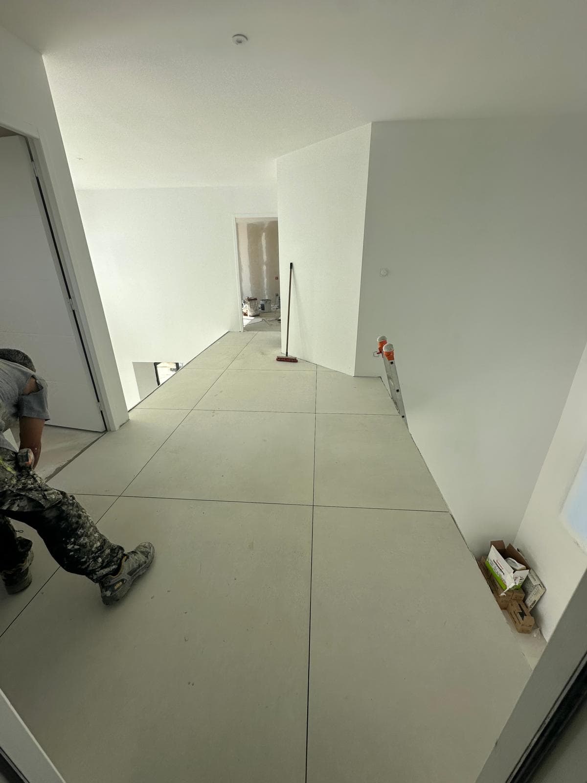 Pose du carrelage sur le palier de la maison neuve