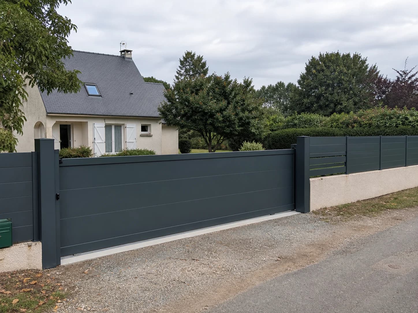 Clôture et portail gris devant une maison en Sarthe