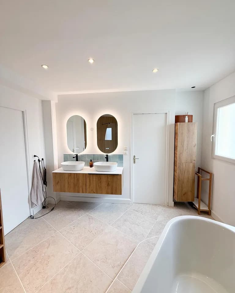 Salle de bain rénovée avec double vasque en bois et baignoire